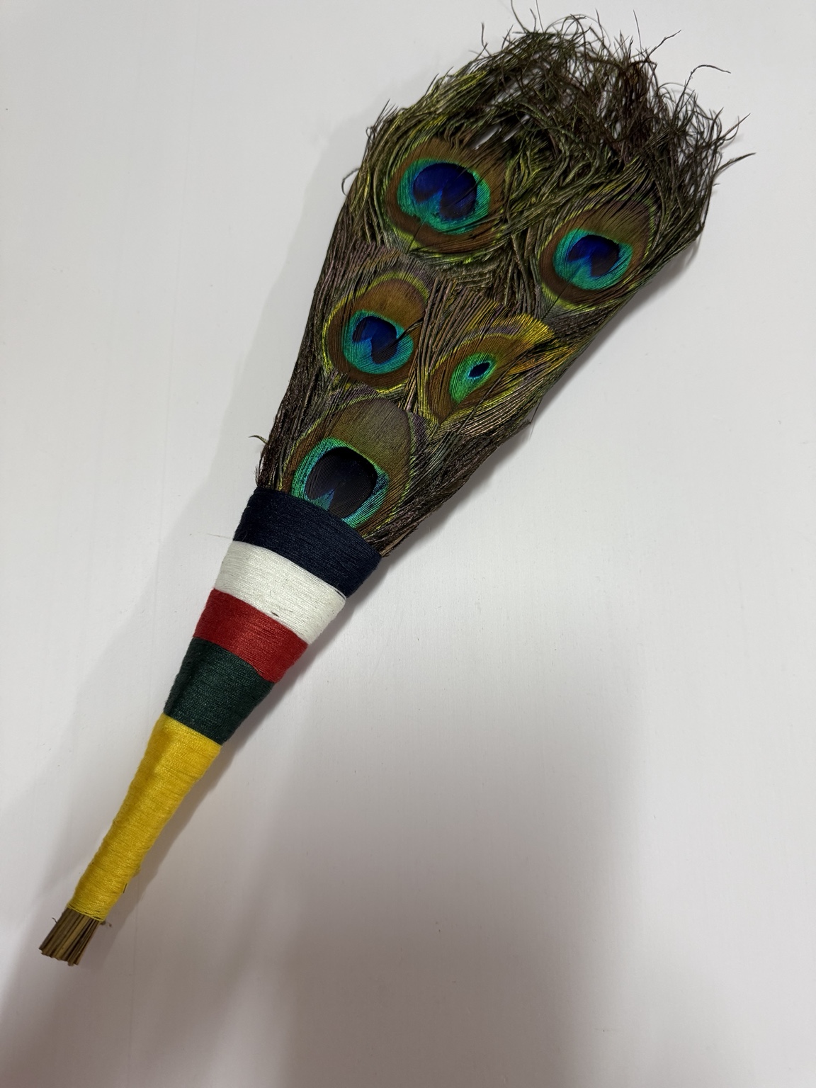 Peacock feather bundle with a five-color thread-wrapped handle